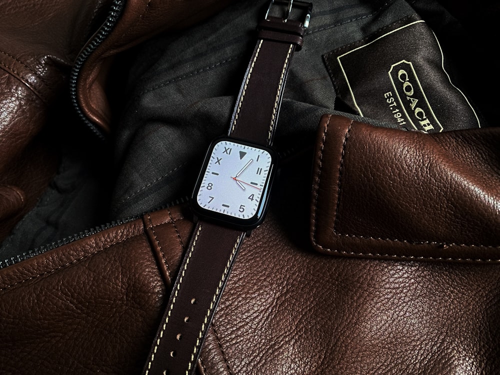 a close up of a watch on a leather bag