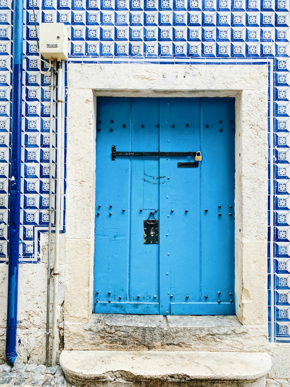 a blue and white door with a bench in front of it