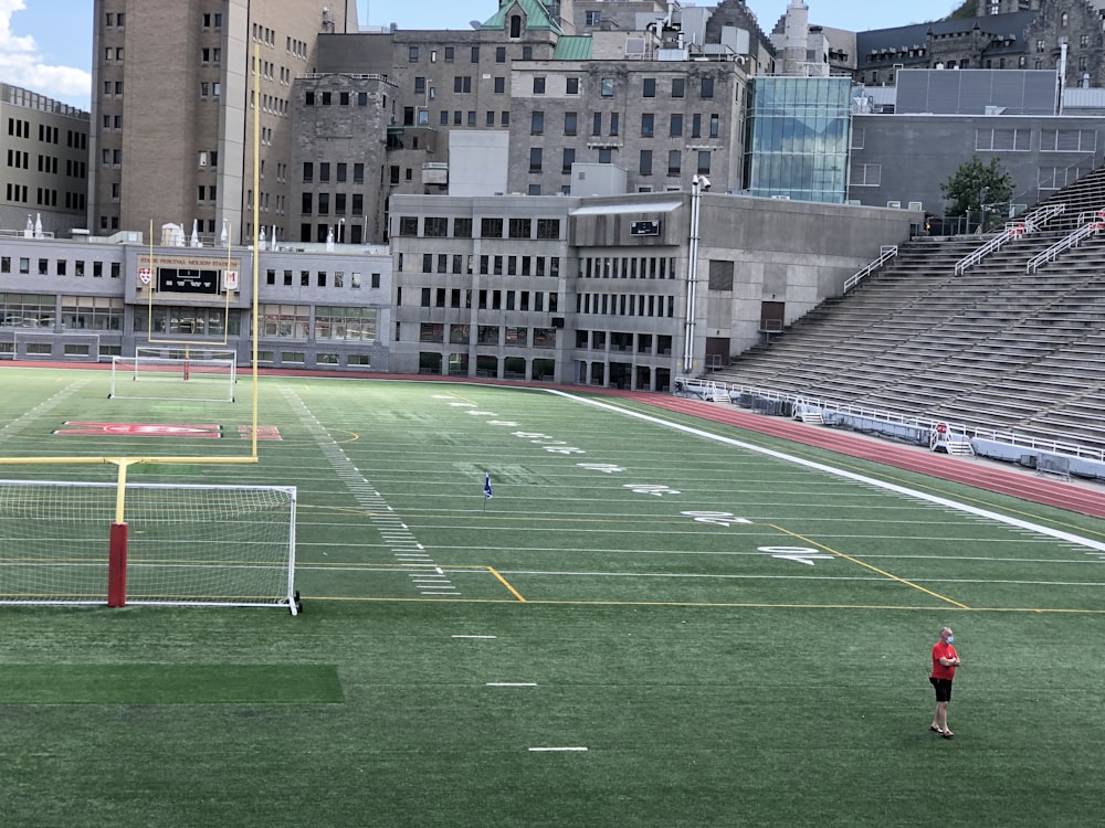 a person standing on a soccer field in front of a stadium