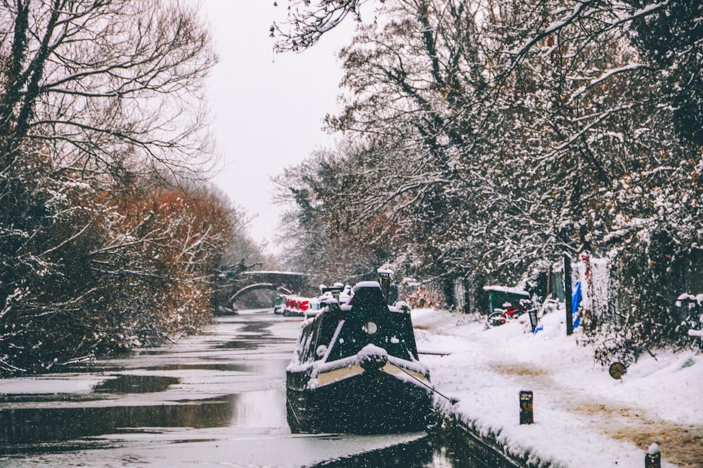 a snow covered boat traveling down a river