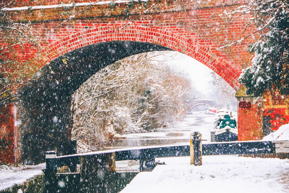 a bridge over a river with snow falling on it