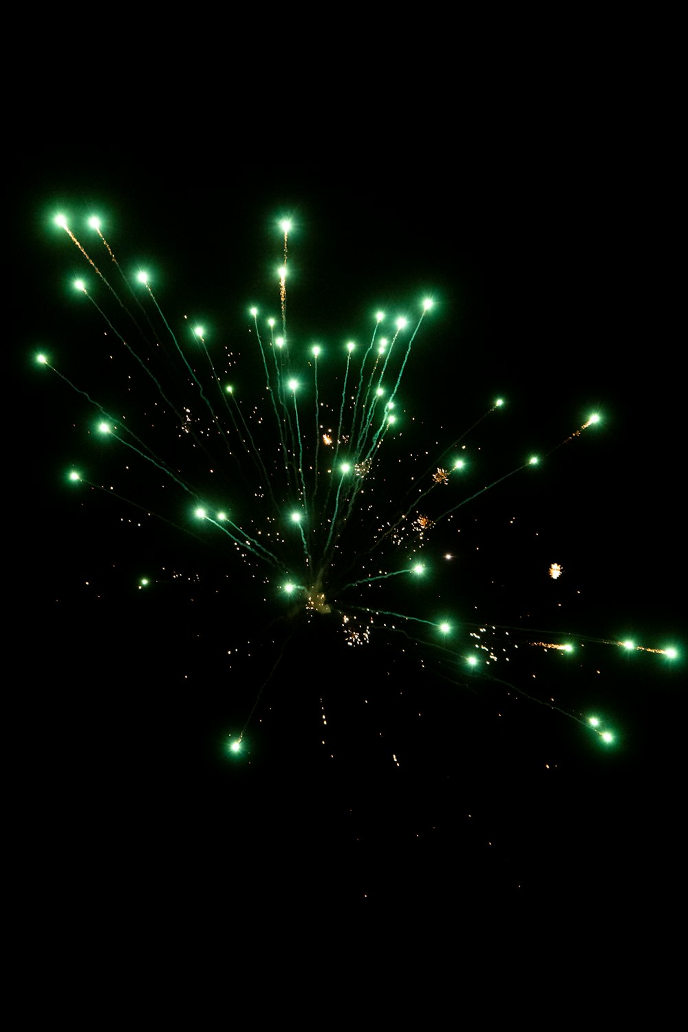 a bunch of green fireworks are lit up in the night sky