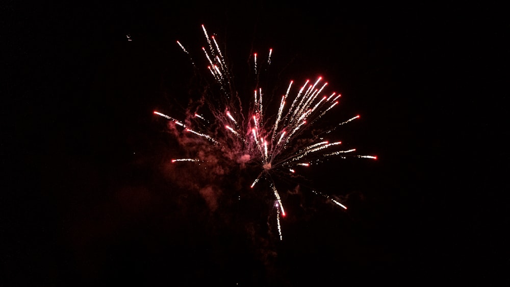 a fireworks is lit up in the dark sky