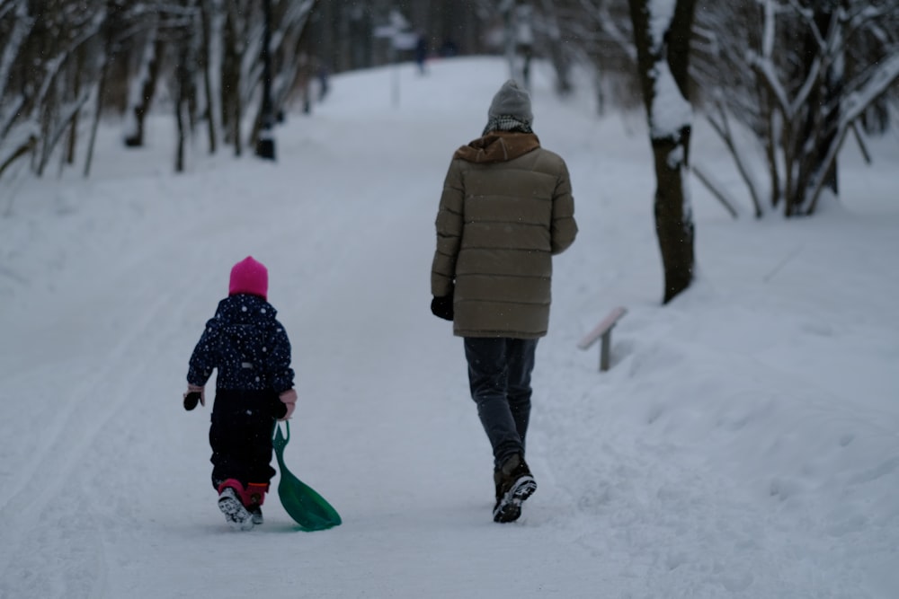 a man and a child are walking in the snow