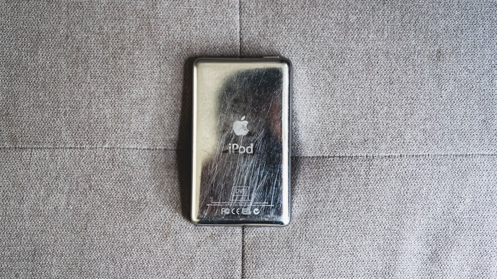 a silver lighter sitting on top of a gray couch