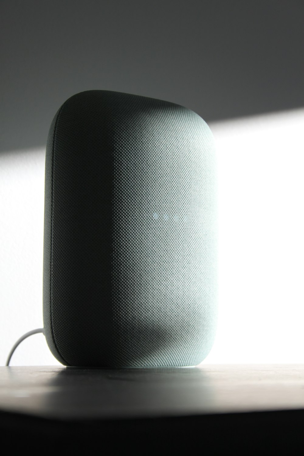 a speaker sitting on top of a wooden table