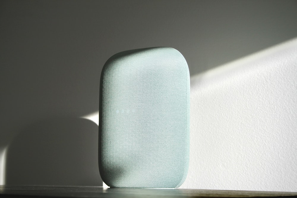 a blue speaker sitting on top of a wooden table