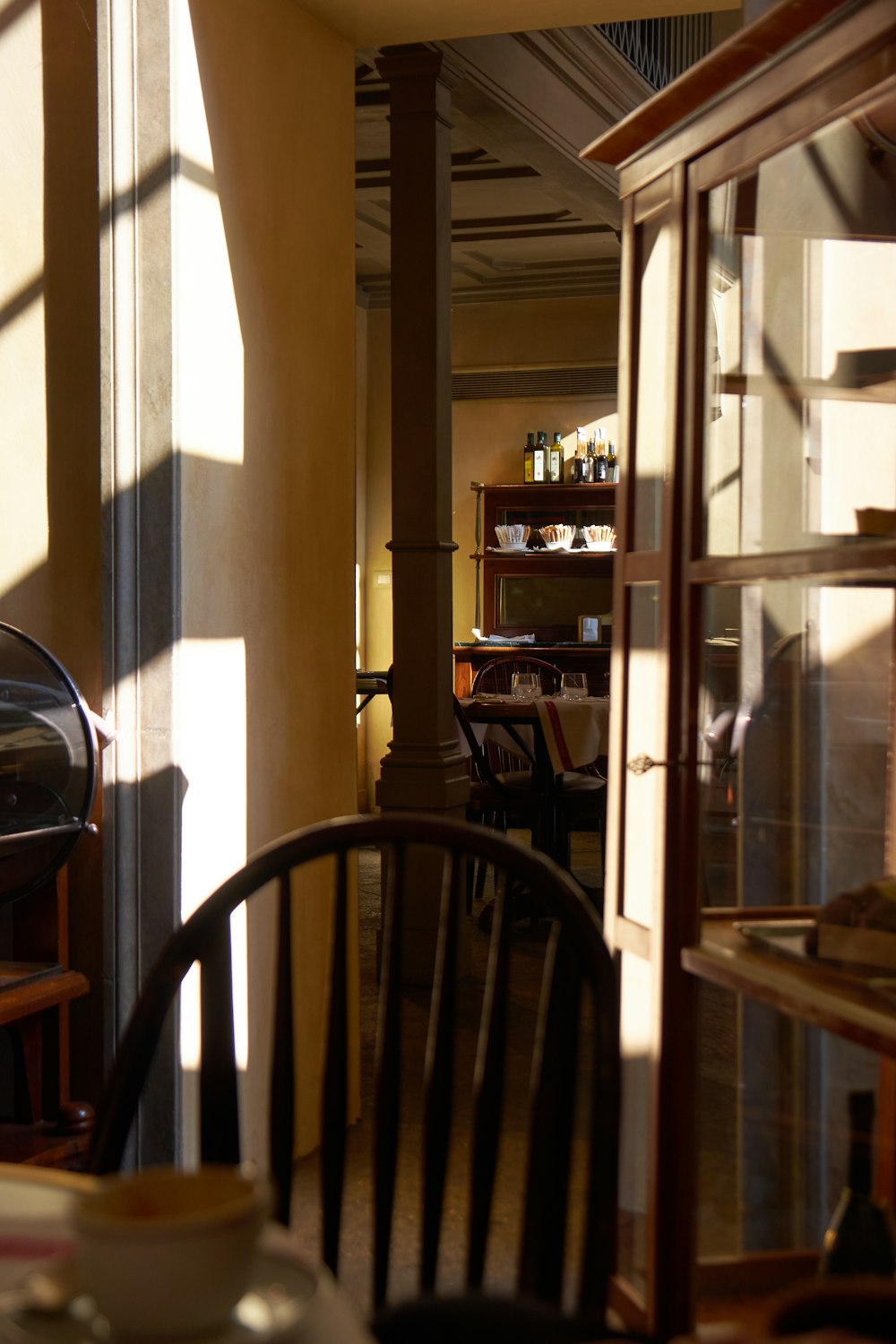 a table and chairs in a room with sunlight coming through the windows