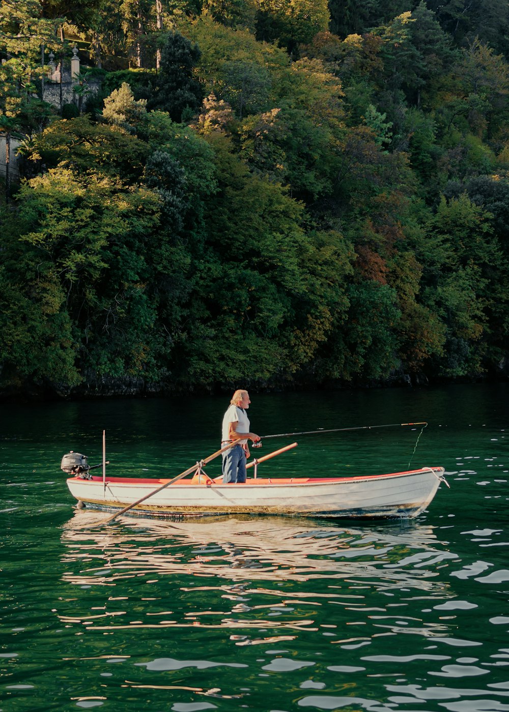 a man standing in a boat on a lake