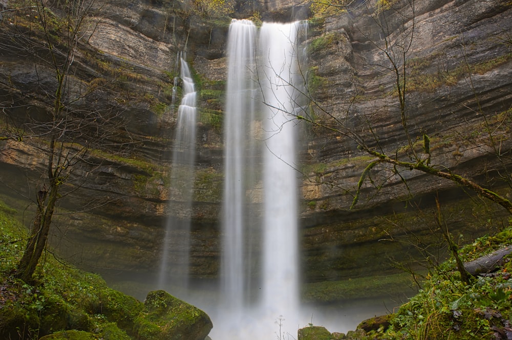 a large waterfall in the middle of a forest