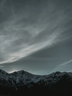 Wide-angle shot of a dramatic mountain range under a moody sky