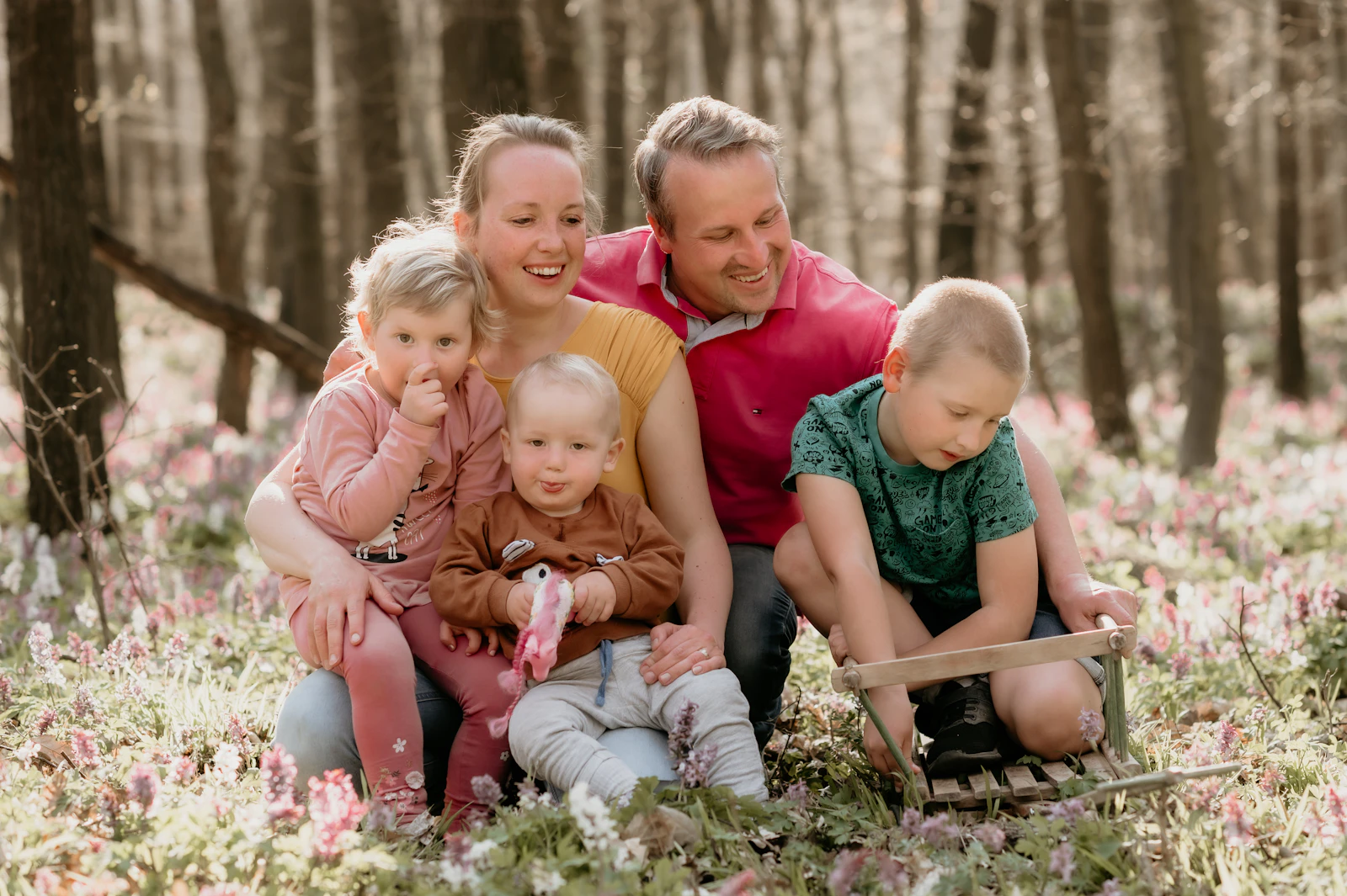 A family seated together on the grass outdoors, representing the wider household time that a holiday respite arrangement can free up