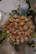 An elegant arrangement of assorted appetizers on a glass platter includes skewers with cheese, cured meat, and vegetables. Savory balls with coating and garnished skewers are visible. A blue candle and greenery add to the decorative background.