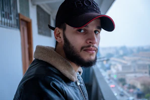 a man with a beard wearing a black hat