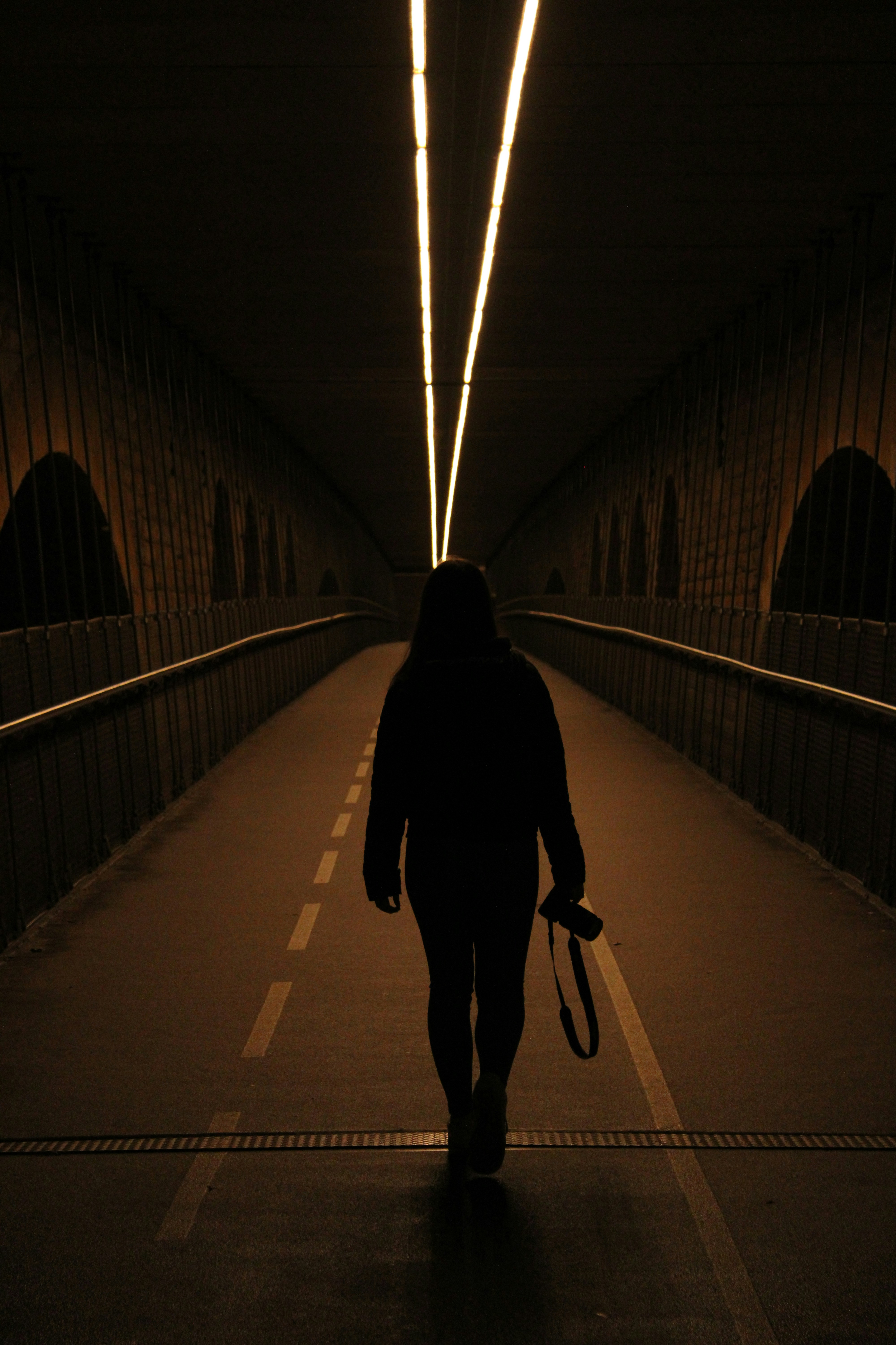 a person walking in a tunnel with an umbrella