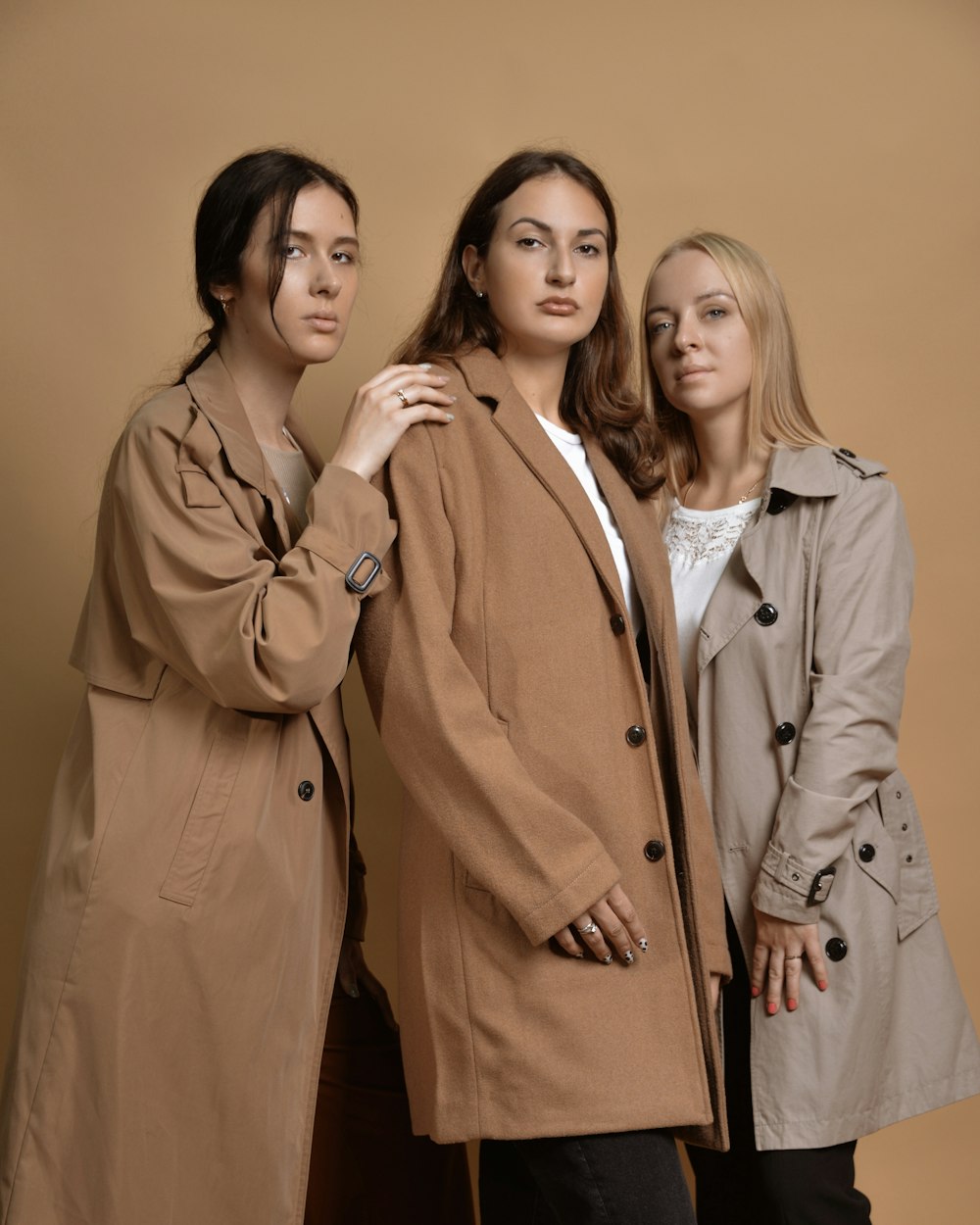 a group of three women standing next to each other