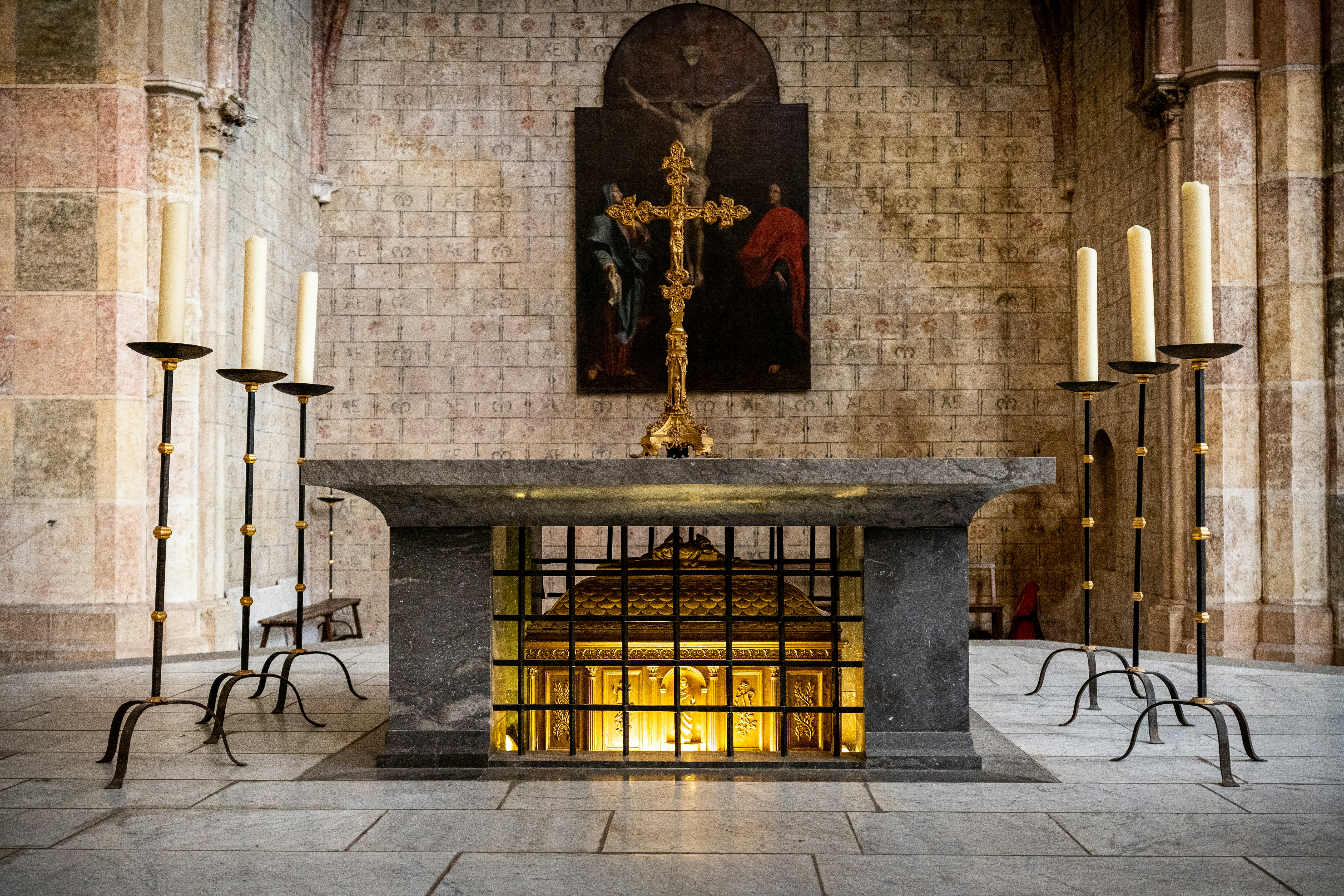 a church with candles and a crucifix in the center, Tomb of St. Thomas Aquinas at the Church of Jacobins