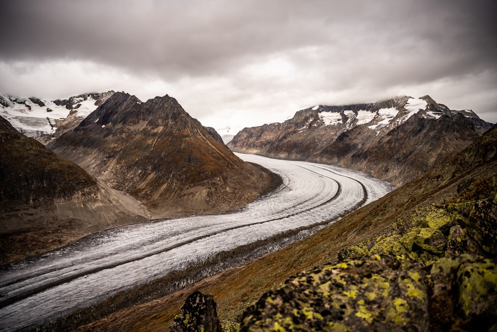 a river running through a valley surrounded by mountains