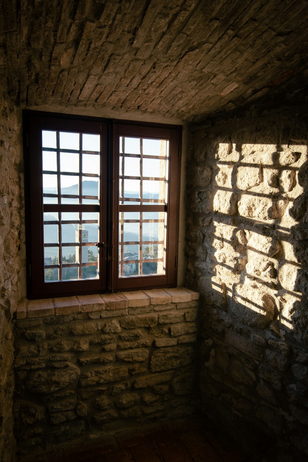 a window in a stone building with a stone wall