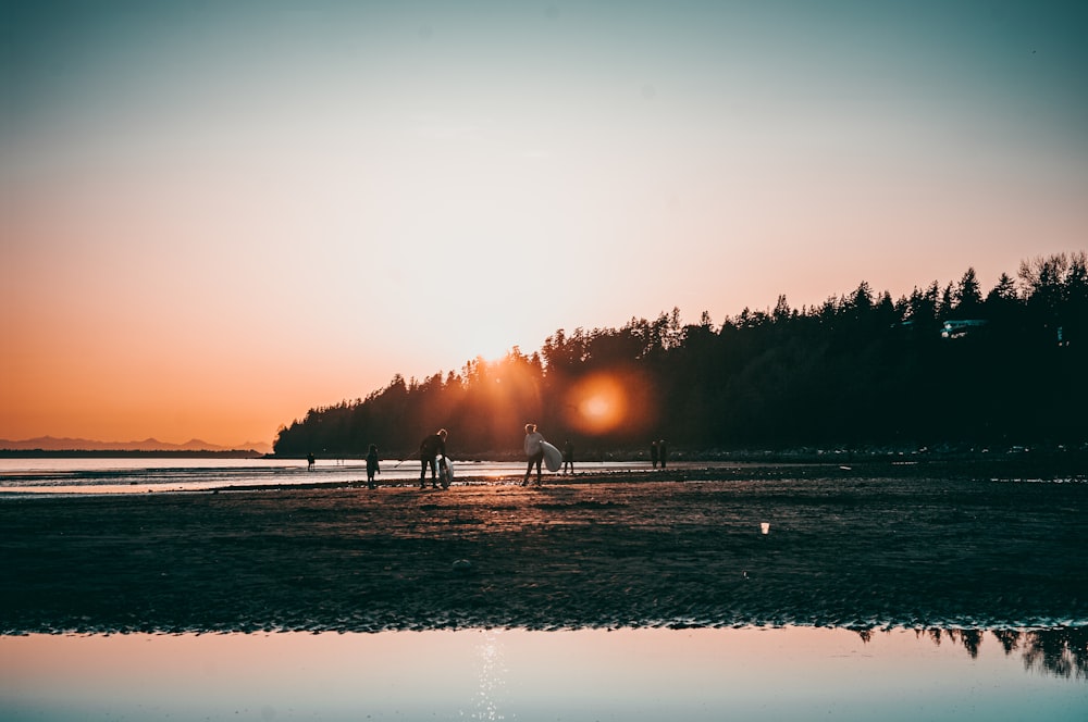 a group of people standing on top of a sandy beach