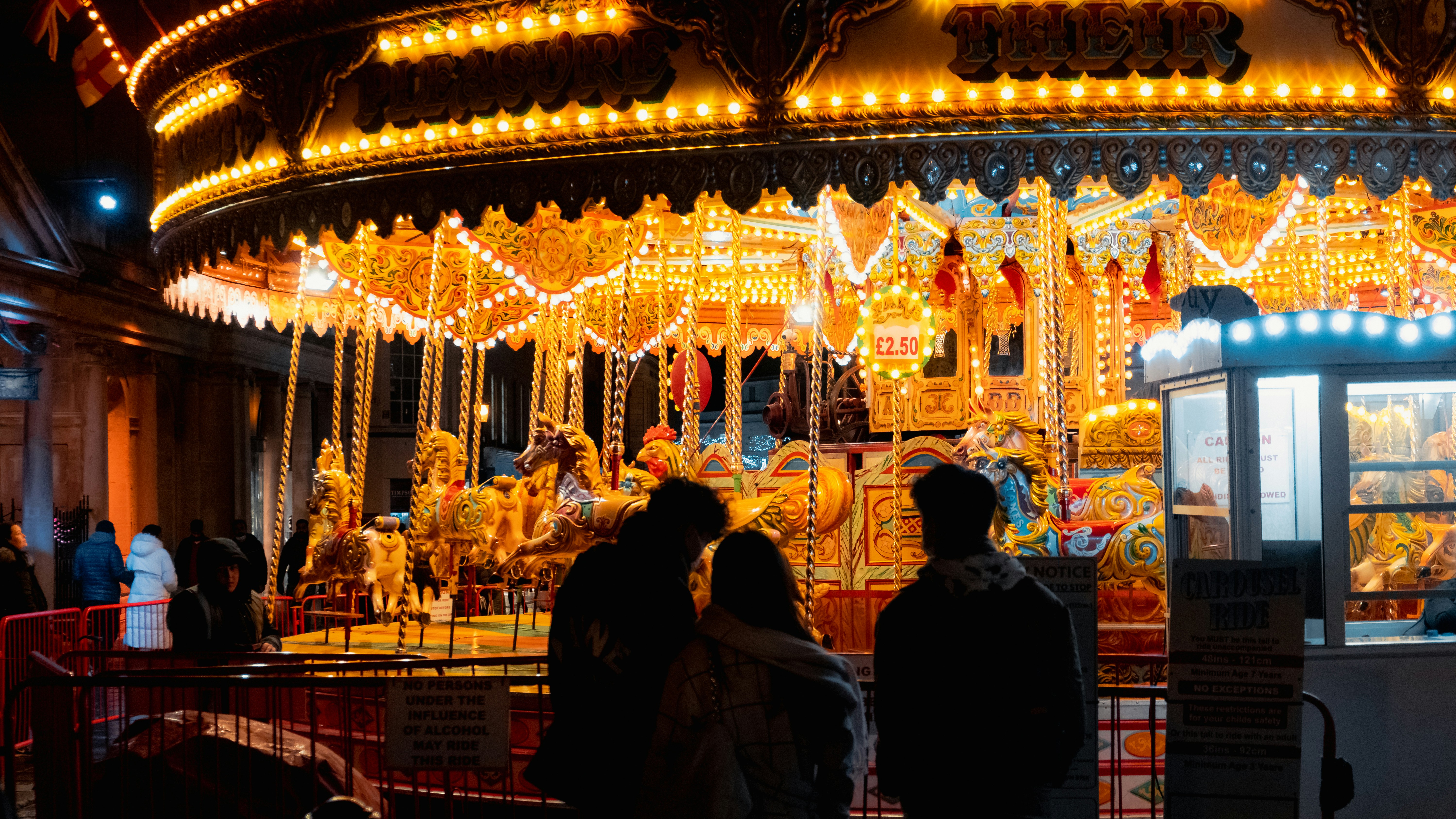 a group of people standing in front of a carousel