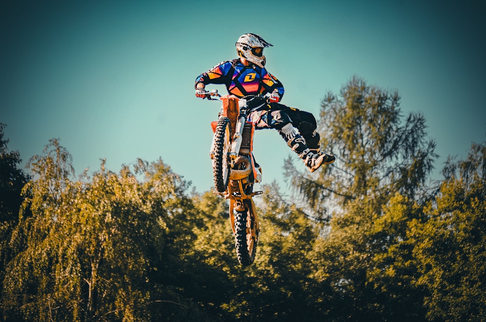 a man riding a dirt bike through the air