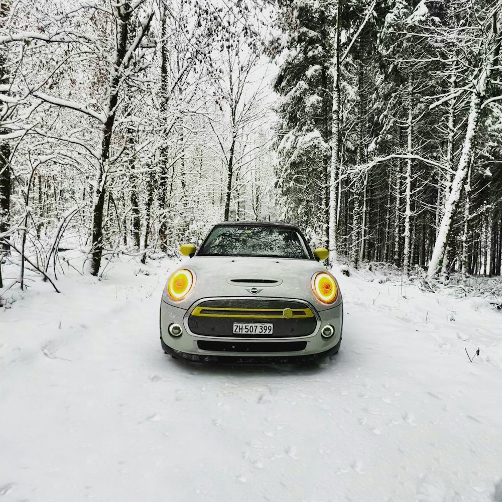 a car parked on a snowy road in the woods