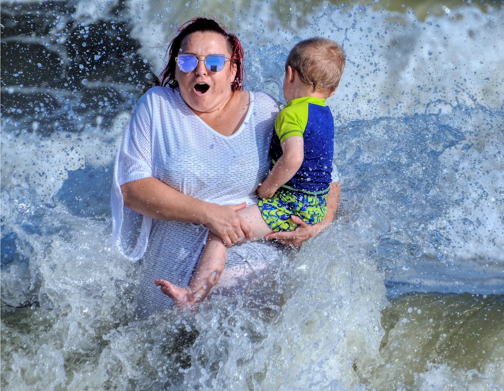 a woman holding a child in the water