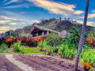 a lush green hillside with a house on top of it
