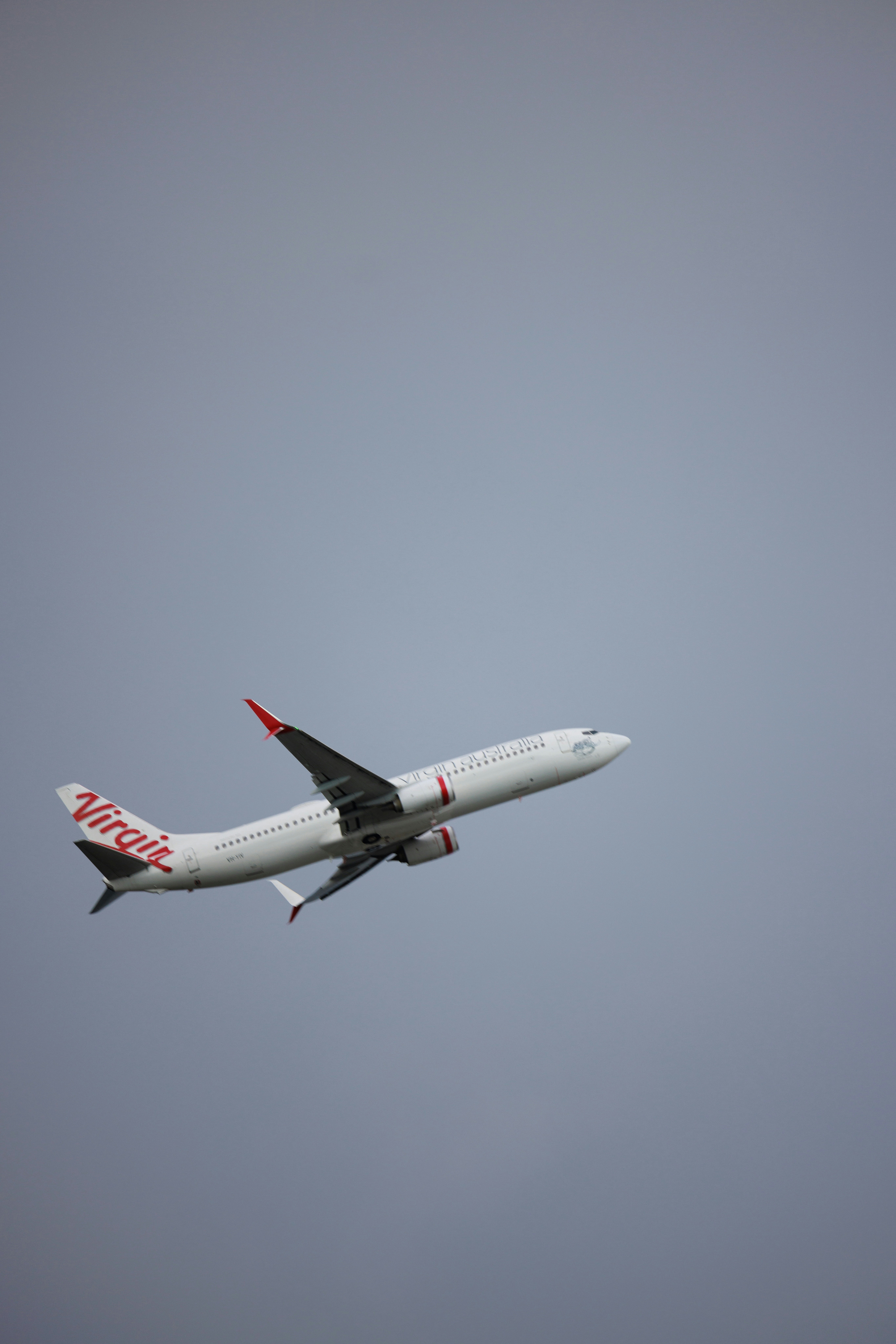 a large jetliner flying through a gray sky