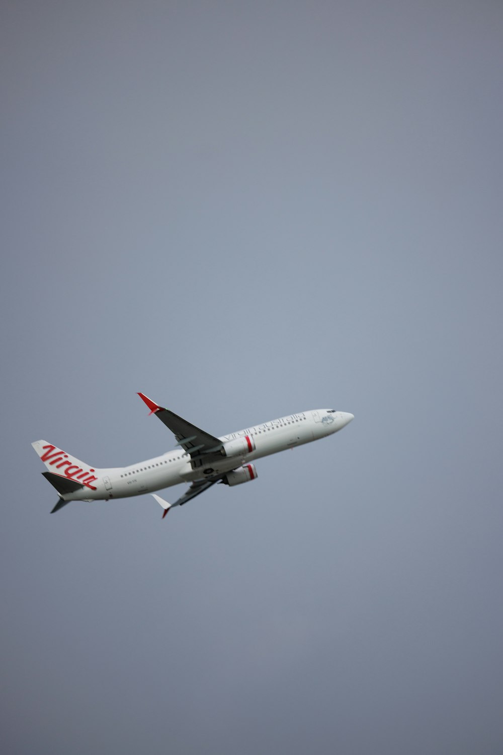 a large jetliner flying through a gray sky