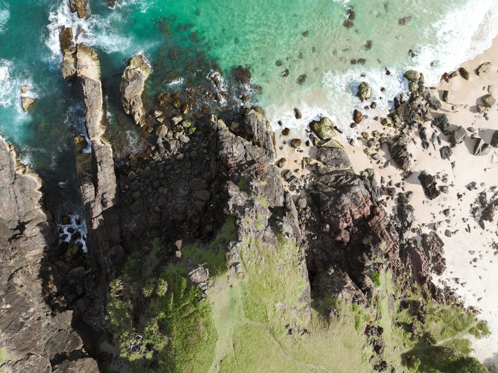an aerial view of a rocky beach and ocean