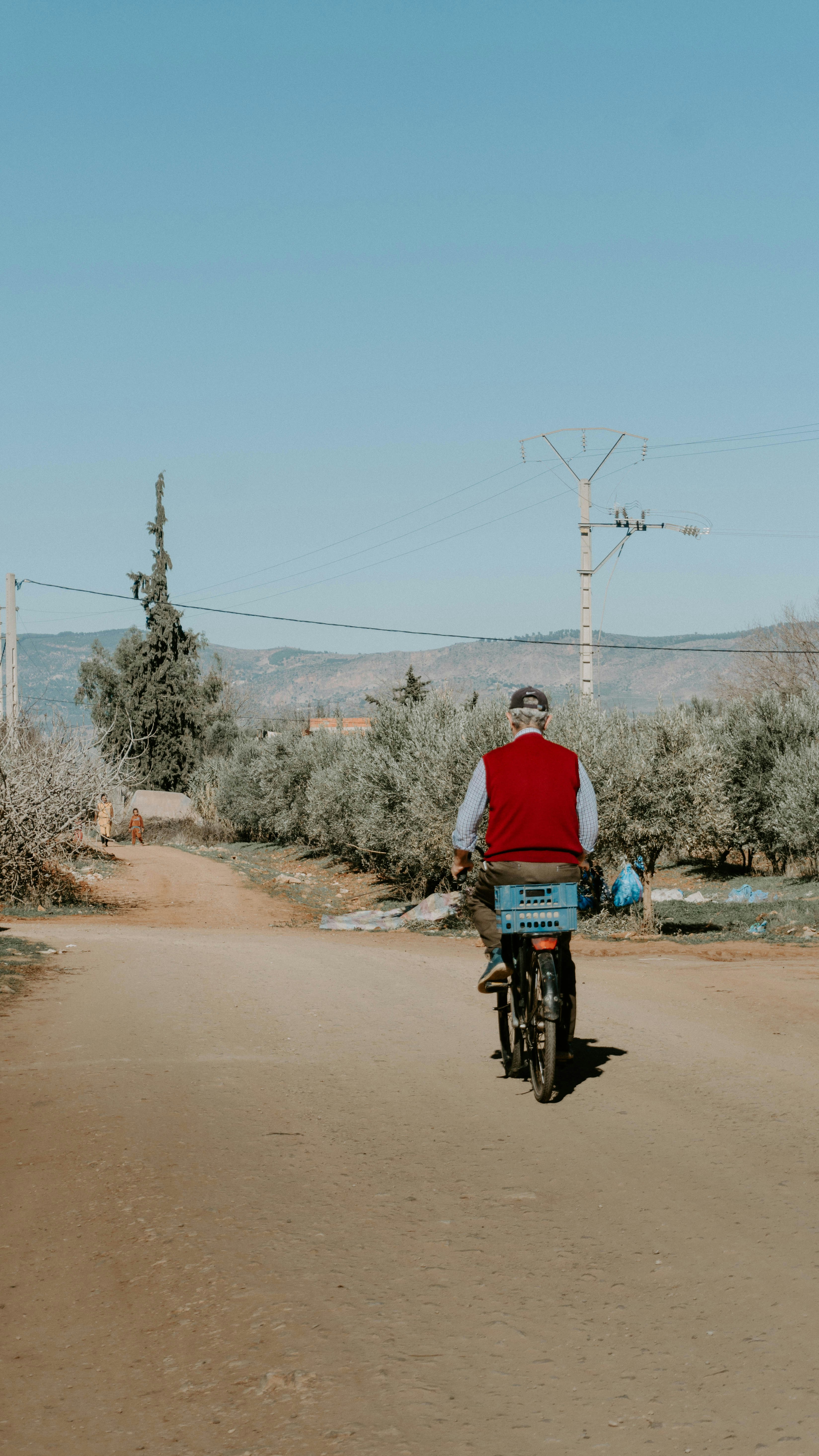 a man riding a bike down a dirt road