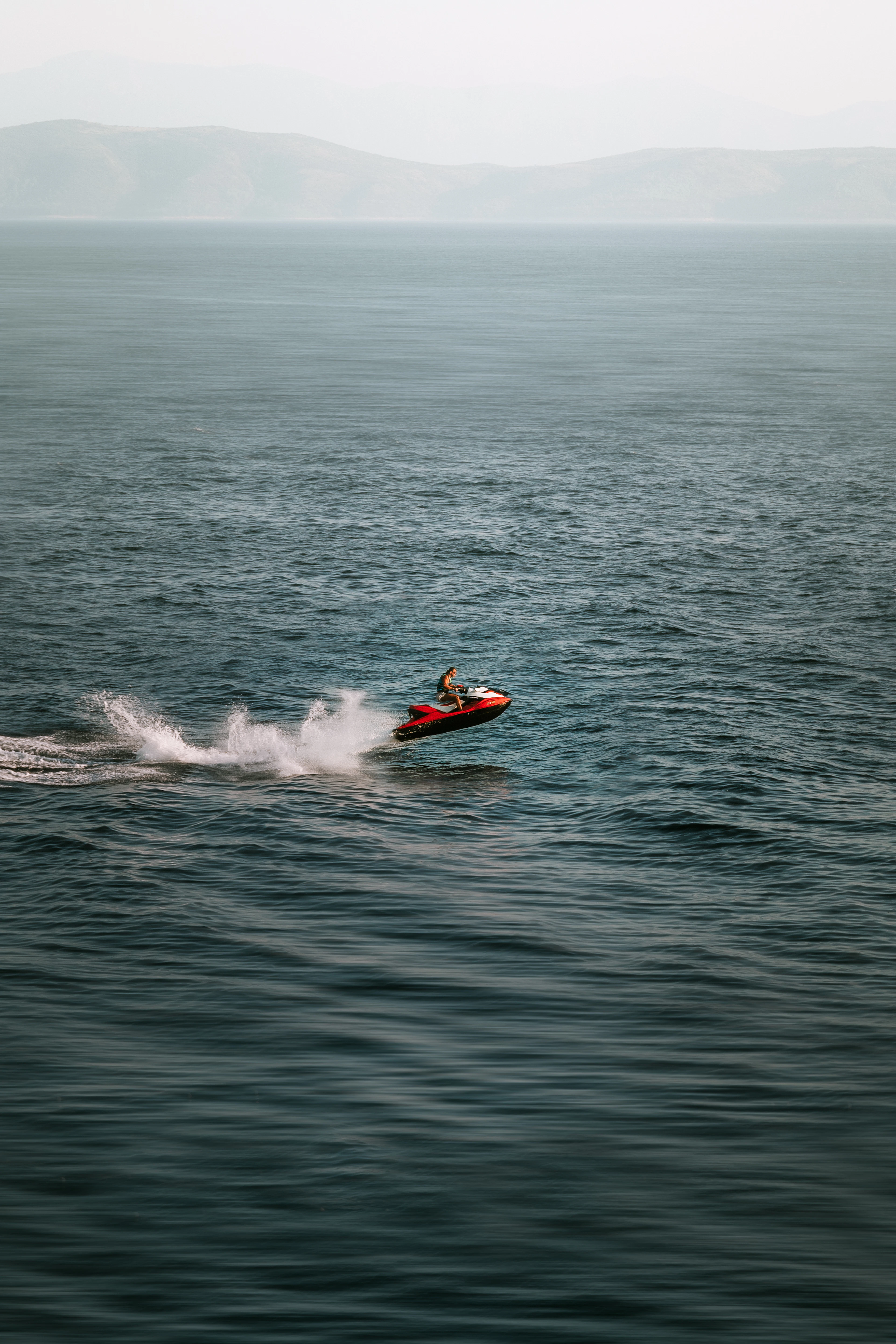 Jet ski jumping across open turquoise ocean water