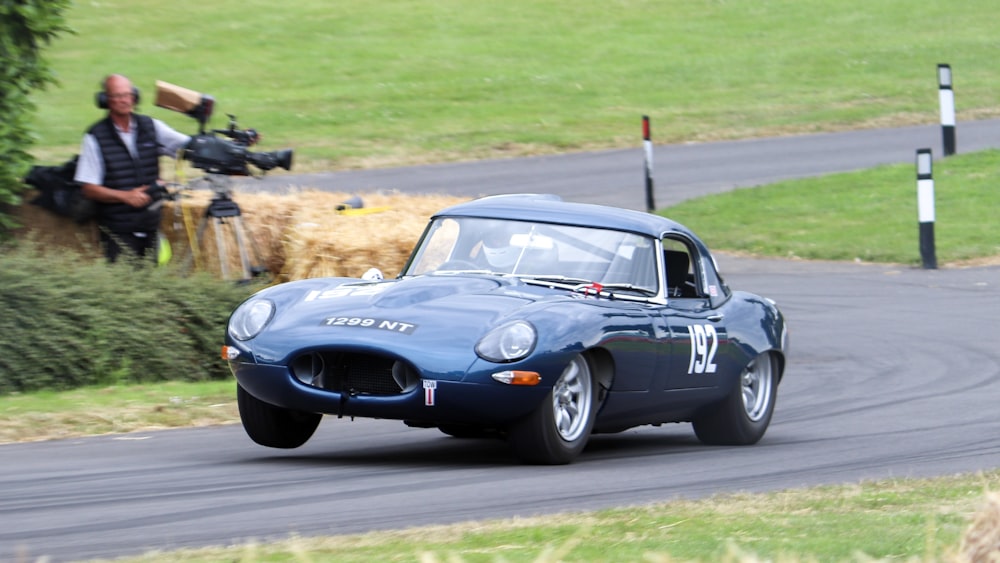 a blue sports car driving down a race track