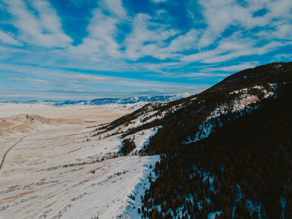 uma vista de uma montanha coberta de neve com um fundo do céu
