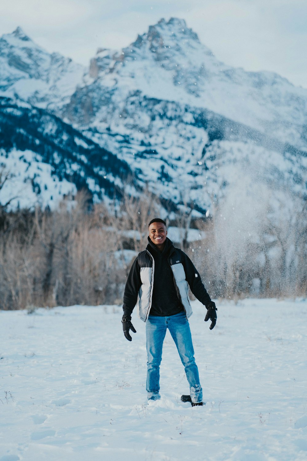山の前で雪の中に立つ男