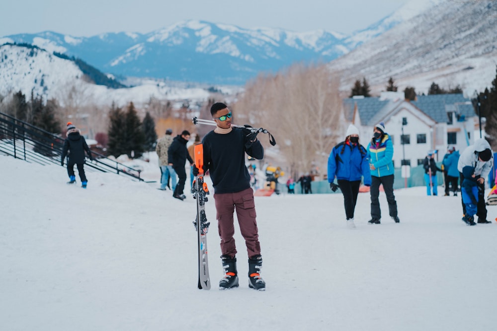 a man standing in the snow holding a snowboard