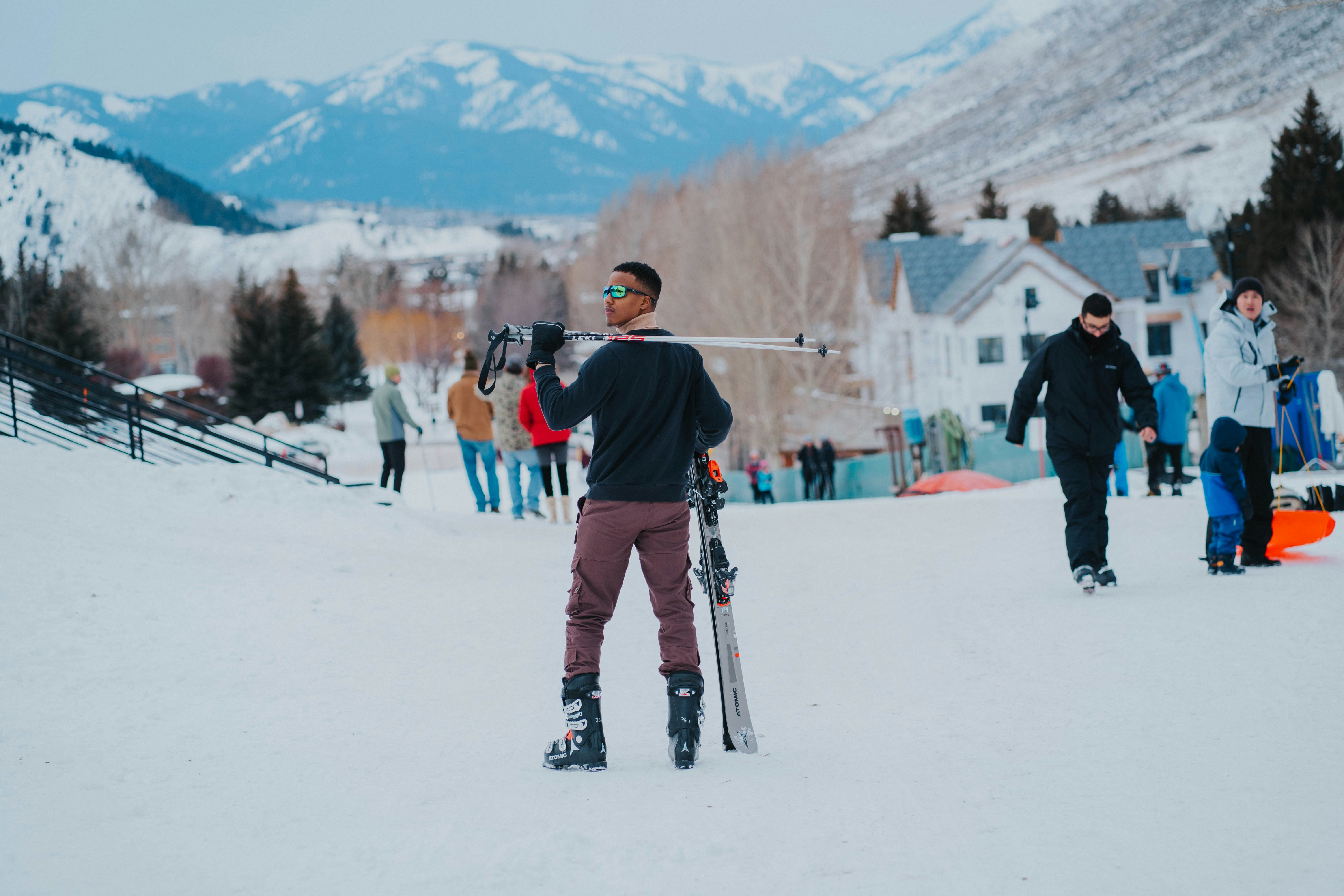 a man holding a pair of skis on top of a snow covered slope