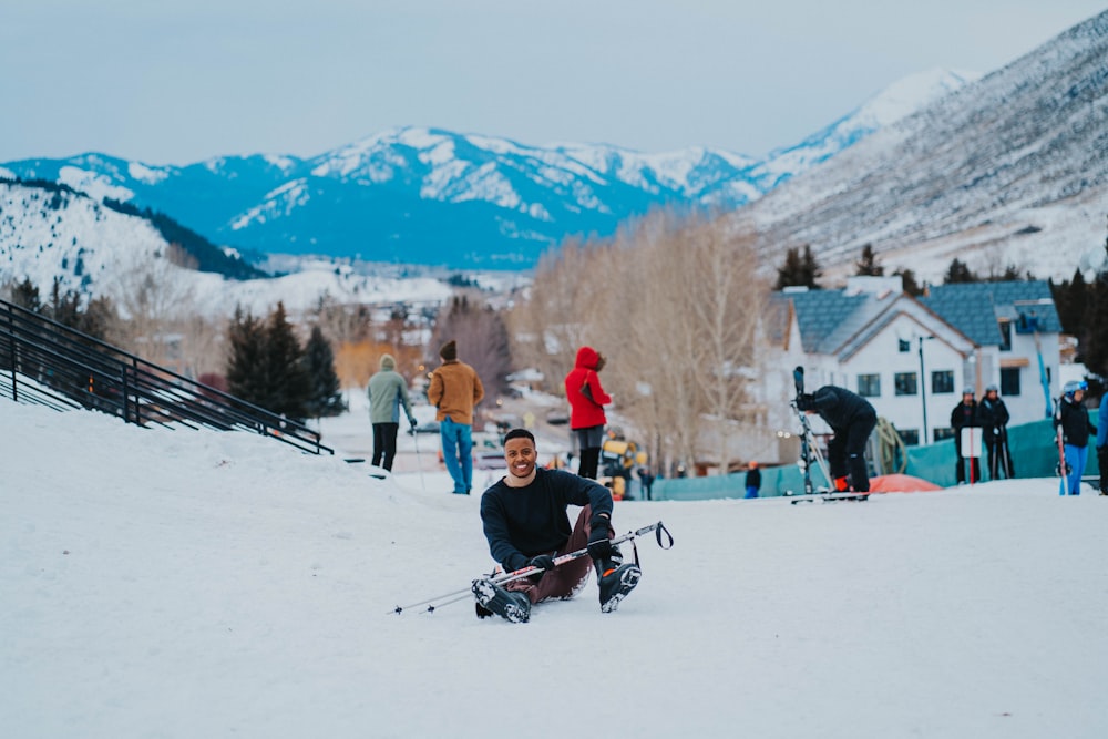 a man sitting on top of a snow covered slope