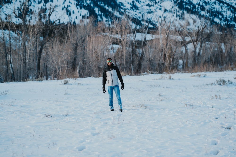 a man riding skis across a snow covered field