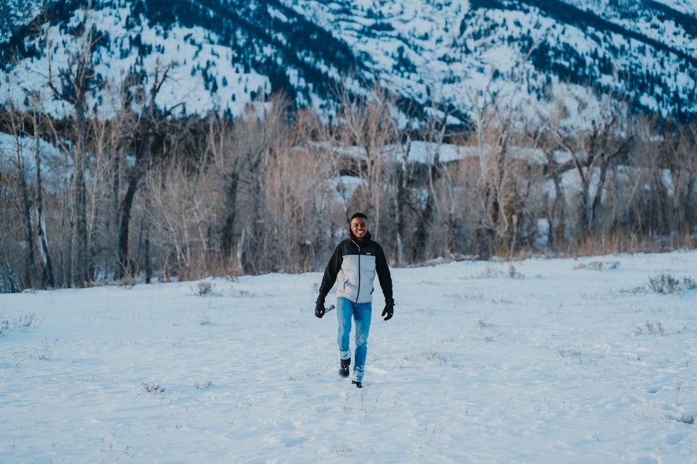 a man walking across a snow covered field