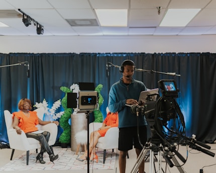 a man and a woman sitting in chairs in front of a camera