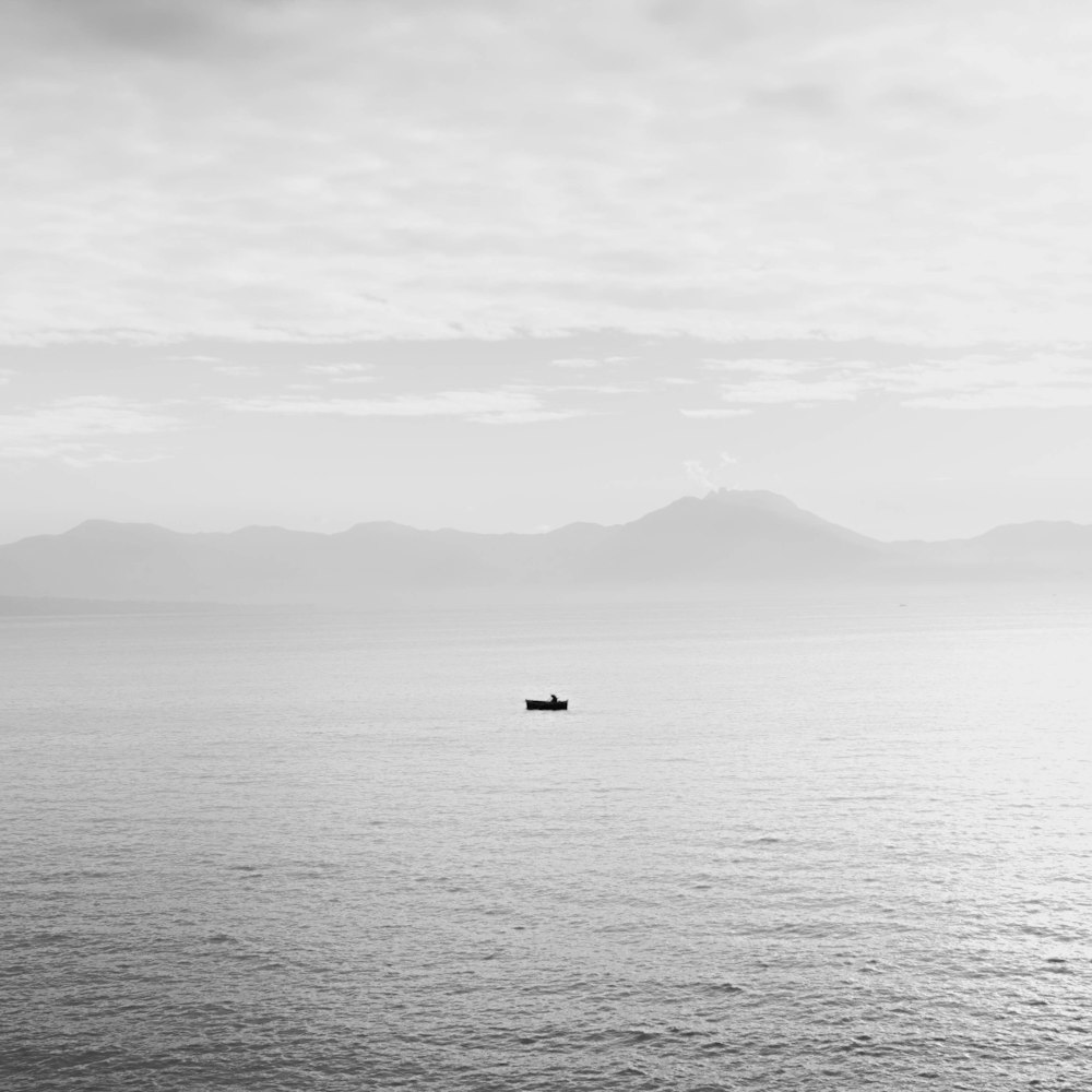 a small boat floating on top of a large body of water