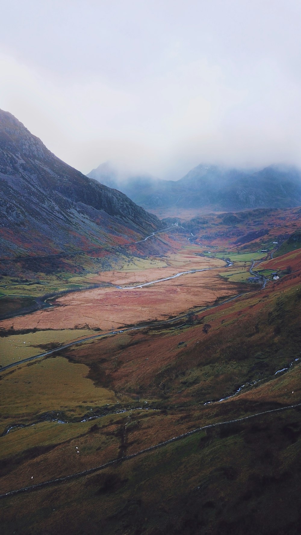 an aerial view of a valley with mountains in the background