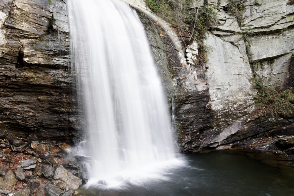 a large waterfall with a man standing next to it