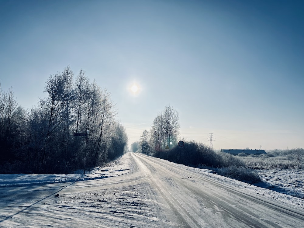 the sun shines brightly over a snowy road