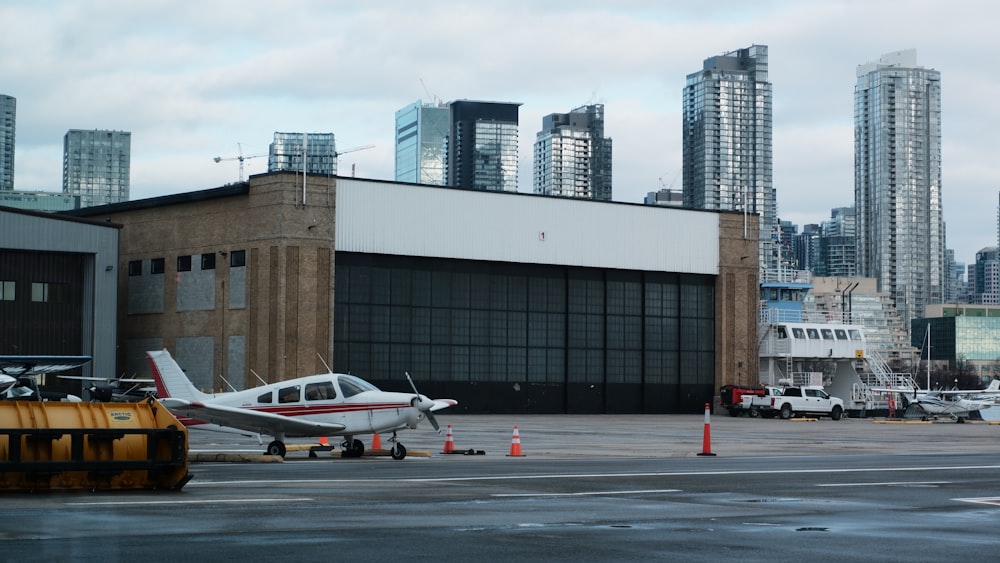 Un petit avion garé devant un grand immeuble
