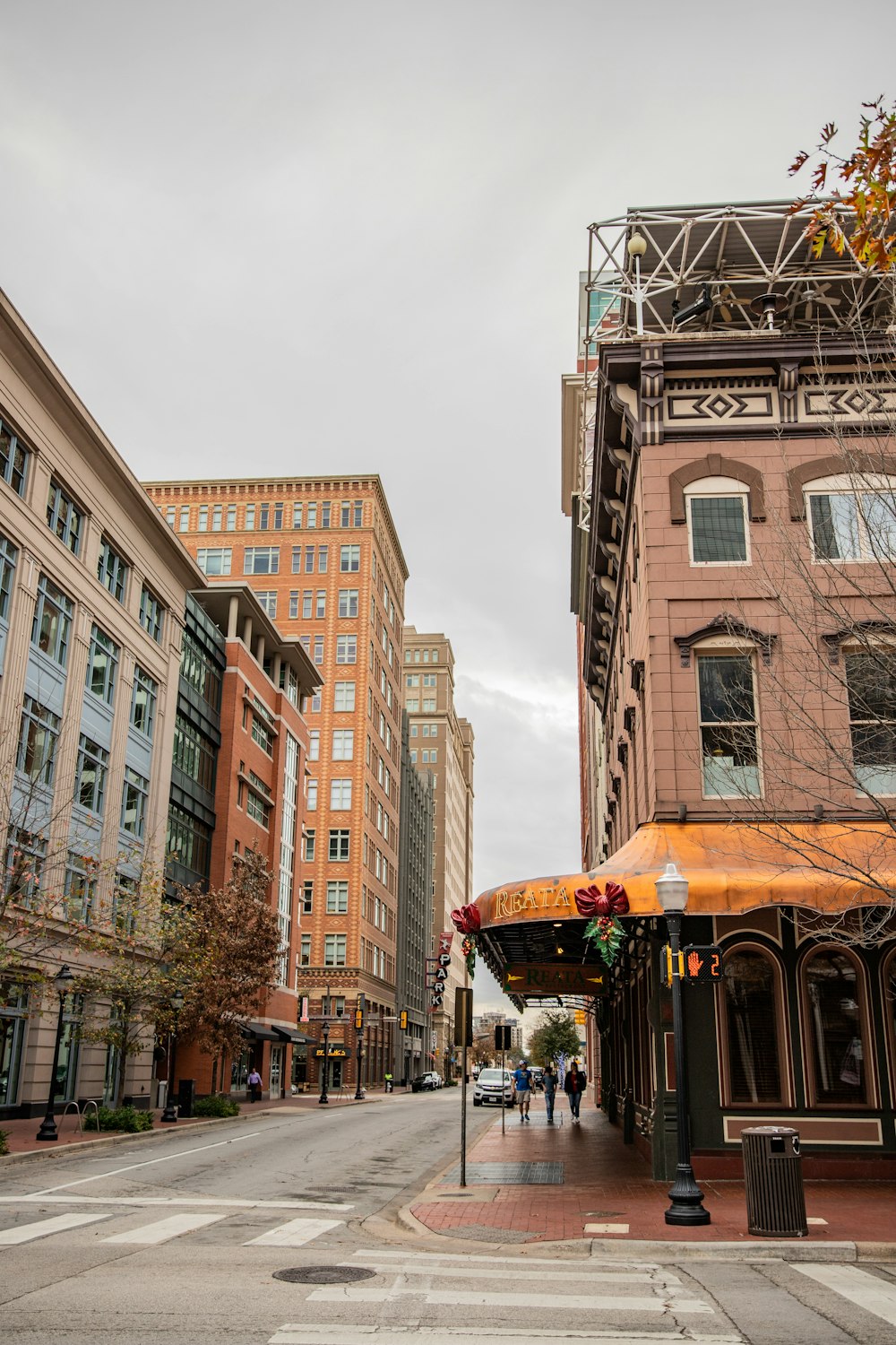 a city street with tall buildings and a yellow awning