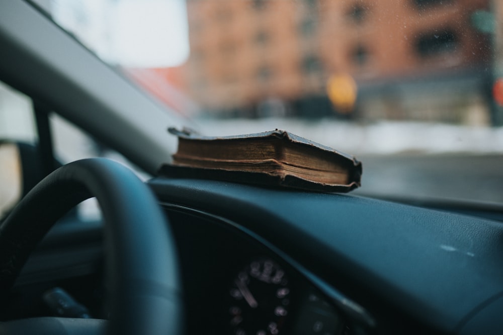 an open book sitting on the dashboard of a car